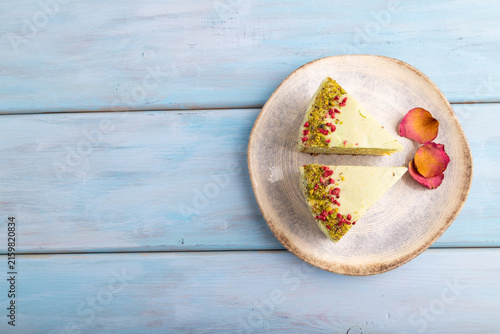 Pistachio green cake on blue wooden, copy space, top view.