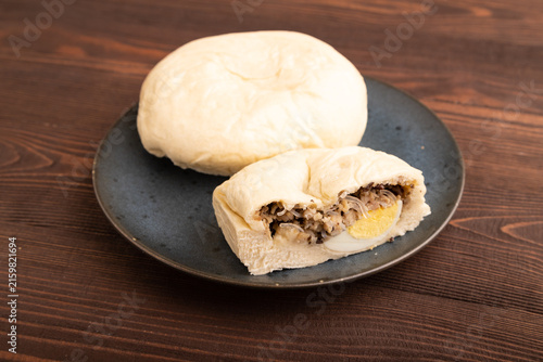 Vietnamese steamed buns Banh bao on brown wooden. side view, close up