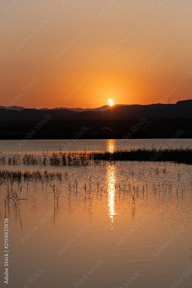 Naklejka premium sunset with partial solar eclipse on the lake