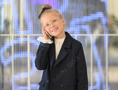 Konstfotografi Portrait of a little girl smiling happily and talking on the phone