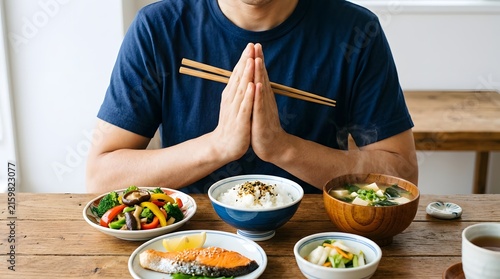 Fototapeta 食事を前に箸を持ち手を合わせる男性