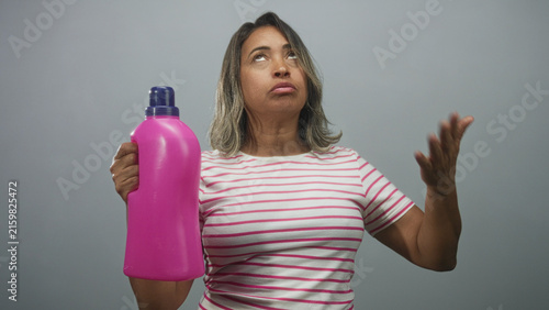 Canvastavla Woman holding bright pink detergent bottle, gestures with hand and looks exasperated in studio; frustration chores