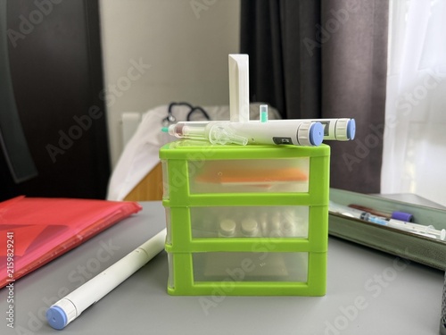 a green box with a medicine and a syringe