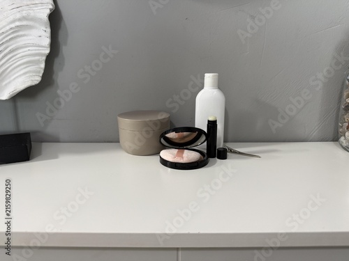 a white dresser with a mirror and a cosmetics set