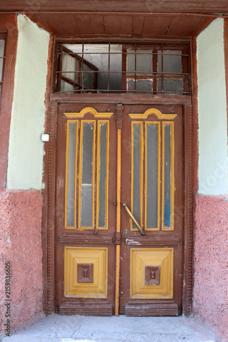 The brown wooden door of a traditional house in Konya. The house's entrance door is closed.