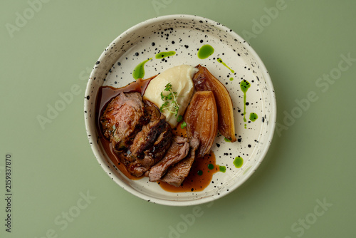 Plate of meat with mashed potatoes and vegetables served on a speckled dish