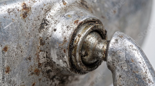 Macro close-up of a rusted and oily metal automotive rearview mirror ball joint adjustment mechanism