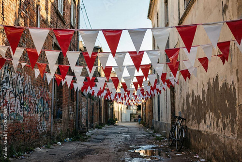 Red and white triangular bunting flags decorating a narrow urban alleyway for celebration