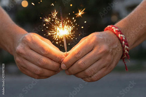 Hands holding a burning sparkler for Indonesia Independence Day celebration