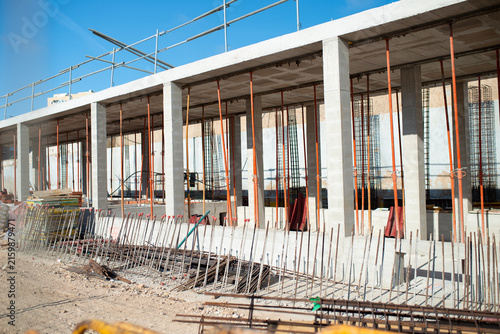 Canvas Print Concrete building under construction with columns, floor slabs, steel reinforcement bars and temporary support posts