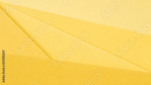 Minimalist yellow paper background, abstract geometric layers of craft paper, textured monochromatic golden backdrop for design