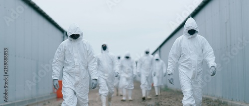 Obraz na płótnie Group in protective hazmat suits walking outdoors