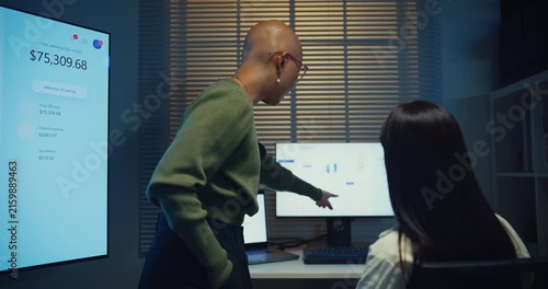 Young Asian businesswomen team meeting work on laptop at office night. Corporate teamwork collaboration, financial report analysis, strategy project planning, colleague development support concept.