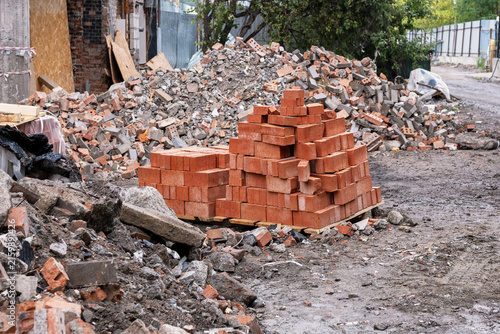 Stacked red bricks on pallet at demolition site