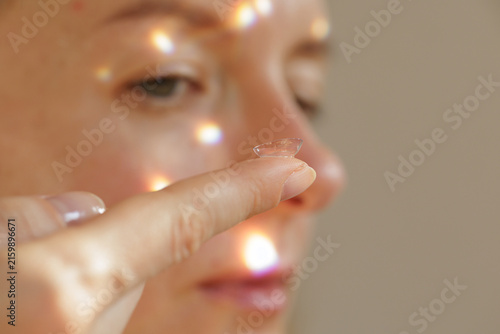 Fotografie Woman Holding Contact Lens on Finger Before Eye Insertion