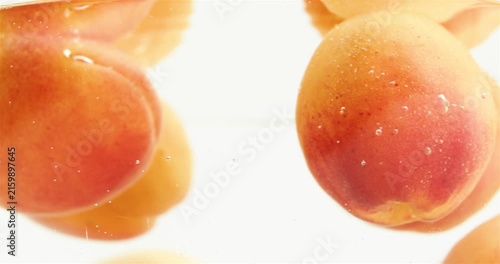 Ripe, juicy, and vibrant apricots in a bowl of water. Fruits and harvest time. Delicious and beautiful summer fruits.