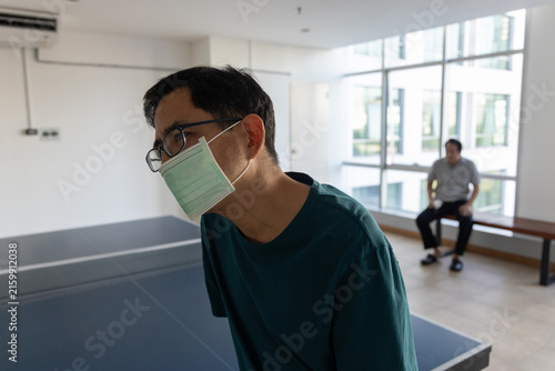 Foto Tired and unwell Asian middle aged man panting, gasping, wearing face mask havin