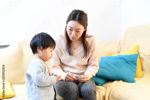 屋内で触れあうアジア人の母親と幼い男の子