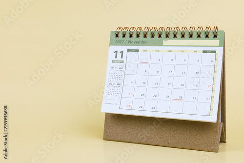 Desk calendar standing on a light yellow background displaying November 2027, ideal for planning, schedule management, and time organization.