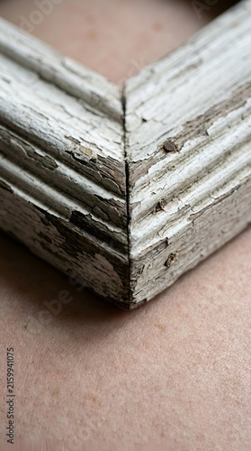 Weathered white wooden frame corner with vintage chipped paint texture and aged rustic patina, for retro design background and antique interior decoration
