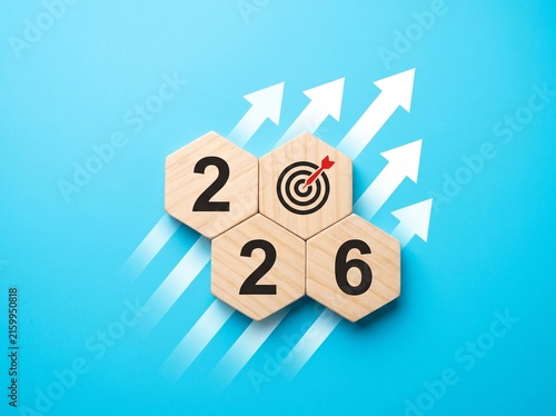 Year 2026 Business Growth Concept with Wooden Hexagon Tiles, Target Icon, and Rising White Arrows on Blue Background
