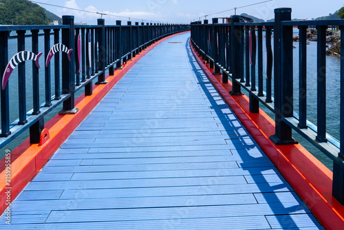 Symmetrical Perspective Along Sky Blue Wooden Coastal Footbridge