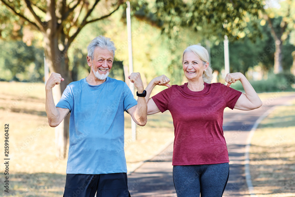 Fototapeta premium Portrait of a senior elderly woman and man, a couple, exercising outdoor, workout and training in park. Mature female and male person happy doing cardio exercise for health, walking or running outside