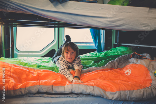 Children, having fun in camper van while heavy raining outdoors, playing and making mischiefs