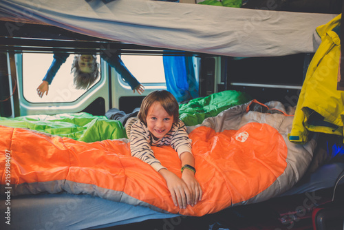 Children, having fun in camper van while heavy raining outdoors, playing and making mischiefs