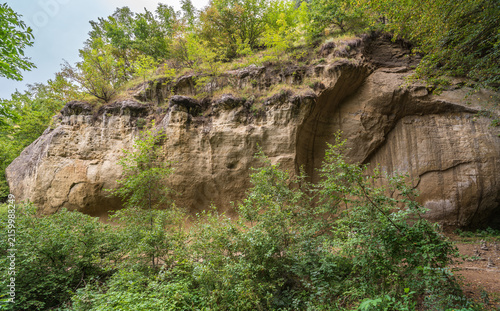 View of the cliffs and grottoes in Kislovodsk. Majestic rocky cliffs and towering trees against blue sky. View of the rocks in Kislovodsk, Russia.