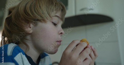 Caucasian kid boy enjoy eating peach in kitchen. 4K 10-bit