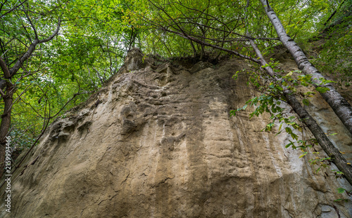 View of the cliffs and grottoes in Kislovodsk. Majestic rocky cliffs and towering trees against blue sky. View of the rocks in Kislovodsk, Russia.
