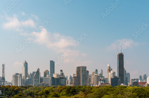 Bangkok skyline of modern high-rise buildings and lush park, photographic style, on a blue sky background, conveying urban growth and travel