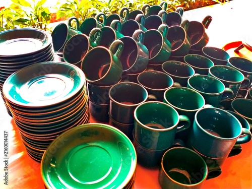 Green Ceramic Cups and Saucers Stacked for Coffee and Tea Tableware