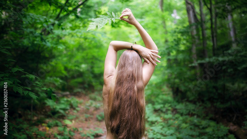 Woman in the forest. View from the back. Enjoying nature.