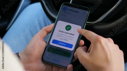 Person submits an insurance claim on a smartphone inside a car, highlighting digital claims processing, mobile insurance services and faster access to financial protection.