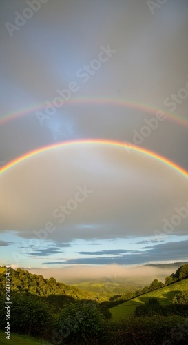Bright Rainbow Arching Perfectly Across a Damp Sky After a Light Rain Shower
