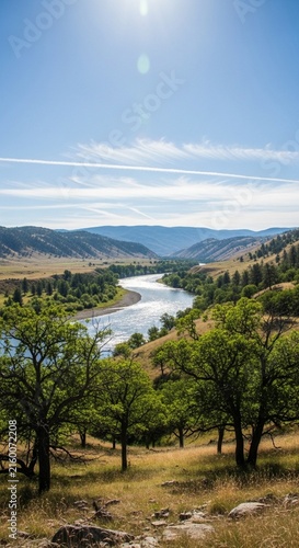 Bright sunlight glinting off a distant river under a clear blue sky