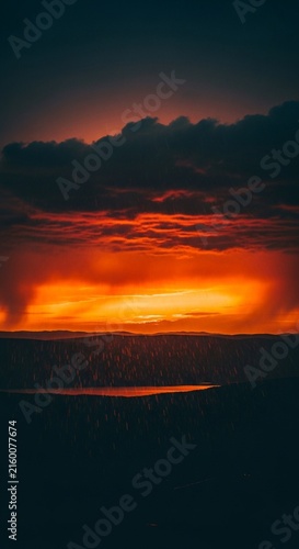 Cinematic Bright Orange Sunset Light Reflecting on the Base of Heavy Rain Clouds