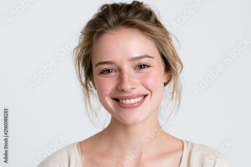 Casually dressed woman in a studio head-and-shoulders shot, warm smile, relaxed and confident