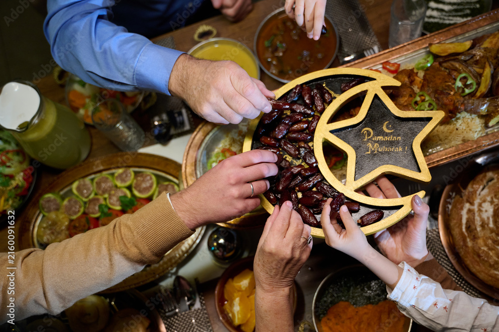 Naklejka premium Family Sharing Dates at Ramadan Iftar Dinner Ramadan Mubarak Celebration With Loved Ones