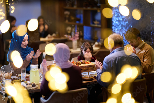 Konstfotografi Muslim Family Praying Together Before Iftar Dinner in Warm Festive Home Setting