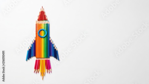 A creative rocket ship made of colorful pencils on a white background