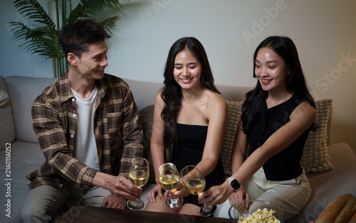 Canvas Print Young Asian friends toasting wine during a cheerful party at home