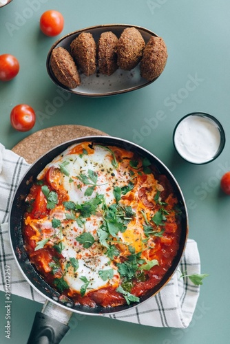 Konstfotografi Traditional Middle Eastern breakfast with skillet shakshuka poached eggs, falafe