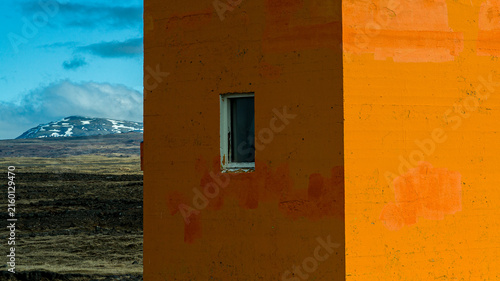 Orange building with snow-covered mountain in Iceland
