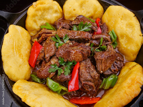 Fotografie Hearty beef stew with potatoes in cast iron skillet - rustic farmhouse cooking w