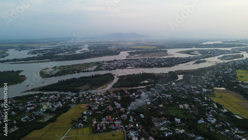 Photography High altitude aerial view of Hoi An city and winding river tributaries in Thu Bo