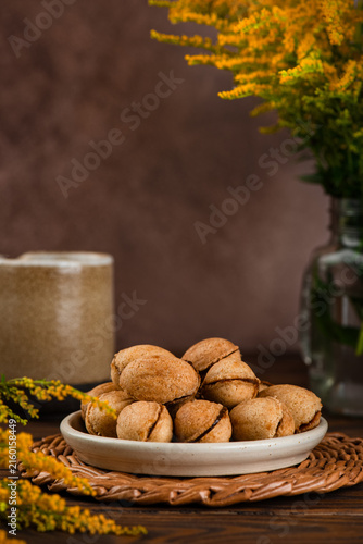 Vegan, sugar and gluten free cookies filled with coconut condensed milk, cozy autumn dessert with coffee. Vertical orientation.