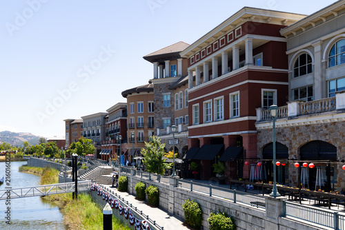 The scenic Napa Riverfront Promenade featuring multi story modern buildings with stone accents.